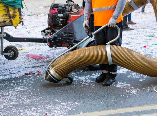 Street cleaner with industrial vacuum cleaner. Municipal cleaning service, clean streets